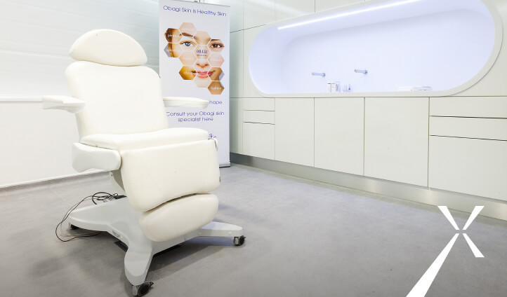 Academy clinic room with patient chair and Obagi banner